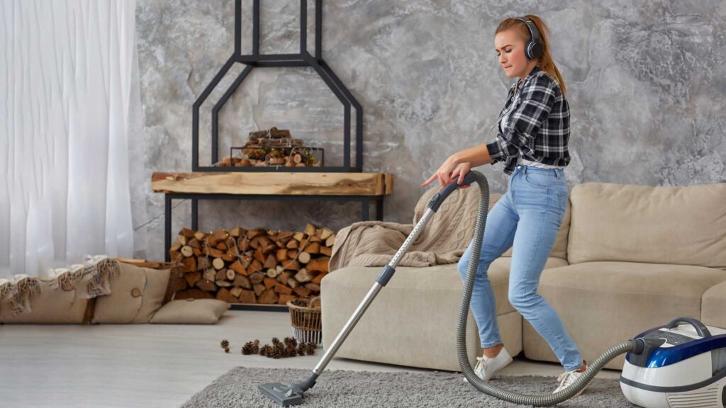 happy woman having fun with vacuum cleaner in the house.