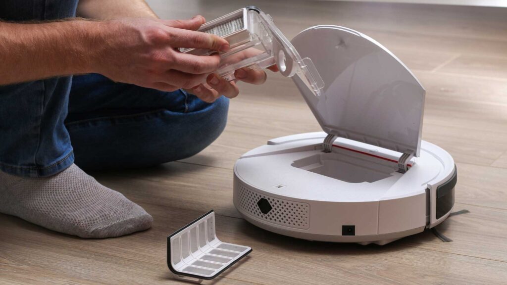 man inserts a filter and a container to collect dust and debris .