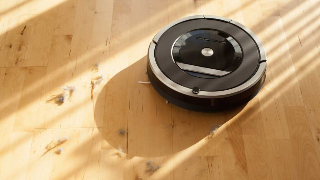 Robotic vacuum cleaner on laminate wood floor smart cleaning.